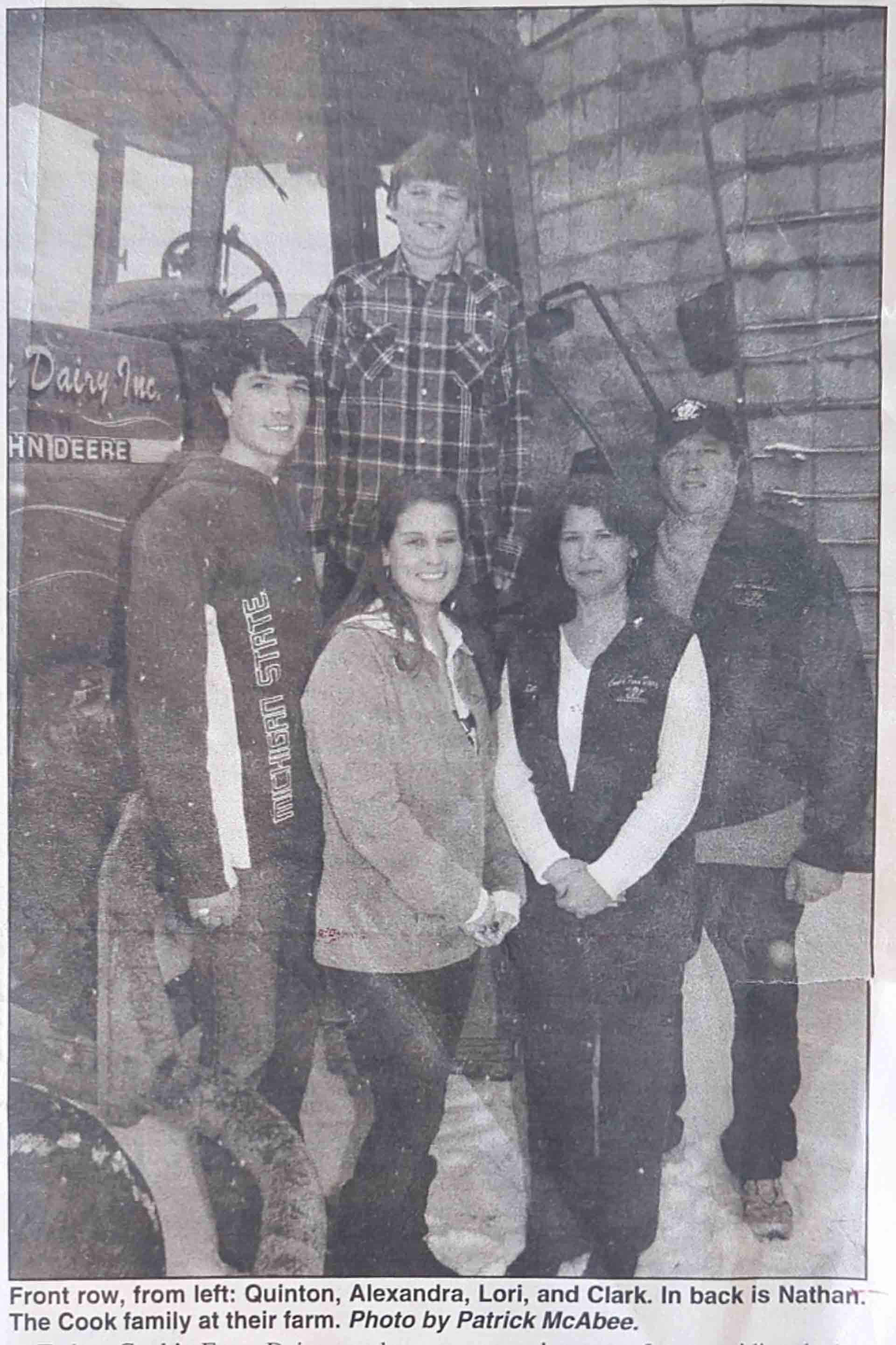 Cooks Farm Dairy Family Pictured on Tractor in front of Silos Photo By The Citizen Ortonville, Michigan